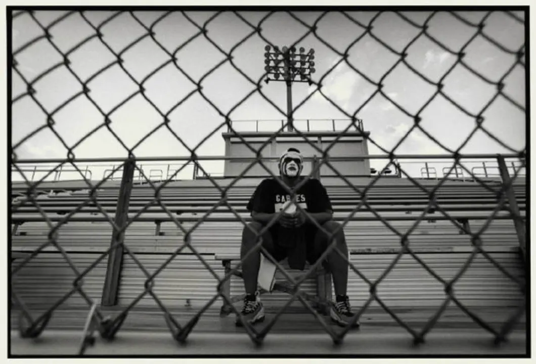 USA. Florida. Coral Gables. 1998. Former Coral Gables High School football player Rafael Burgos sits as a lone fan on the bleachers.