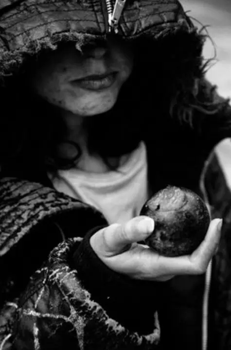USA. San Francisco. 1999. Close-up portrait of a homeless person eating a plum.