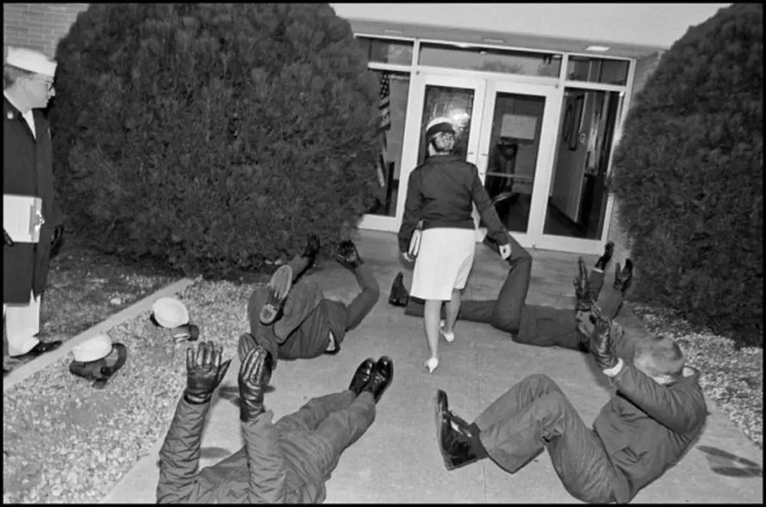 USA. Orlando, Florida. 1993. Female Commanding Officer, Lt. Pat Lackey, walks through male recruits, being punished, while she enters company HQ at 6:00 AM.
©Eli Reed / Magnum Photos
No photograph or digital file may be reproduced, cropped, or modified (digitally or otherwise) and its captions may not be altered without prior written agreement from Magnum or a Magnum representative.