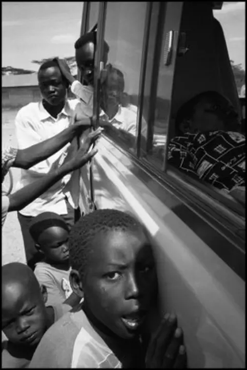KENYA. Kakuma Refugee Camp. August 2001. Refugees surround a UN vehicle.