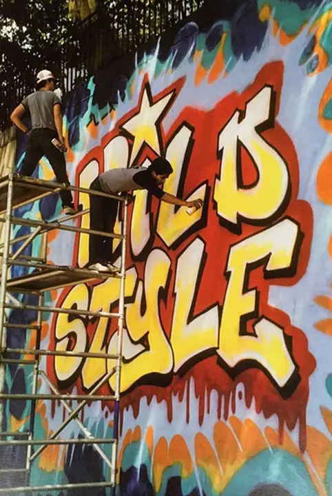 Revolt y Sharp pintando el mural de Wild Style wall, en 1983.
Fotografía por Martha Cooper.