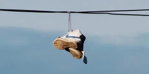 Zapatillas colgadas de los cables el&eacute;ctricos en las calles