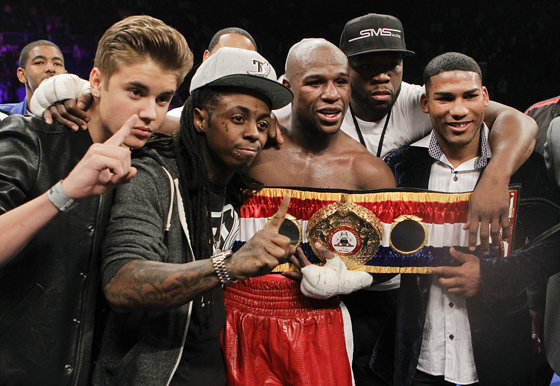 Floyd Mayweather Jr., center, poses for a photo with, from left, Justin Bieber, Lil' Wayne, 50 Cent and Cuban boxer Yuriyorkis Gamboa after defeating Miguel Cotto for the WBA super welterweight title, Saturday, May 5, 2012, in Las Vegas. (AP Photo/Eric Jamison)