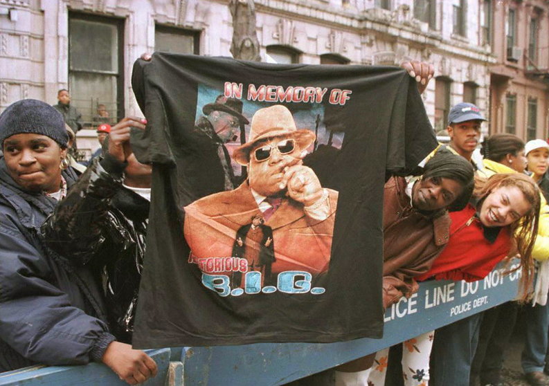 BROOKLYN, :  A man displays a T-shirt tribute to rapper Biggie Smalls aka The Notorious B.I.G 18 March as friends and fans lined the funeral procession route through his old neighborhood in Brooklyn. "Biggie" 24, who's real name was Christopher Wallace, died 09 March in a drive-by shooting in Los Angeles. AFP PHOTO  Jon LEVY (Photo credit should read JON LEVY/AFP/Getty Images)