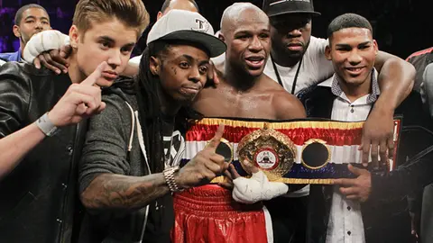 Floyd Mayweather Jr., center, poses for a photo with, from left, Justin Bieber, Lil' Wayne, 50 Cent and Cuban boxer Yuriyorkis Gamboa after defeating Miguel Cotto for the WBA super welterweight title, Saturday, May 5, 2012, in Las Vegas. (AP Photo/Eric Jamison)