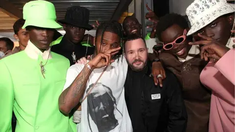 Travis Scott y la directora creativa de Dior Men, Kim Jones, posan en el backstage con los modelos tras el desfile.
Foto: Getty Images